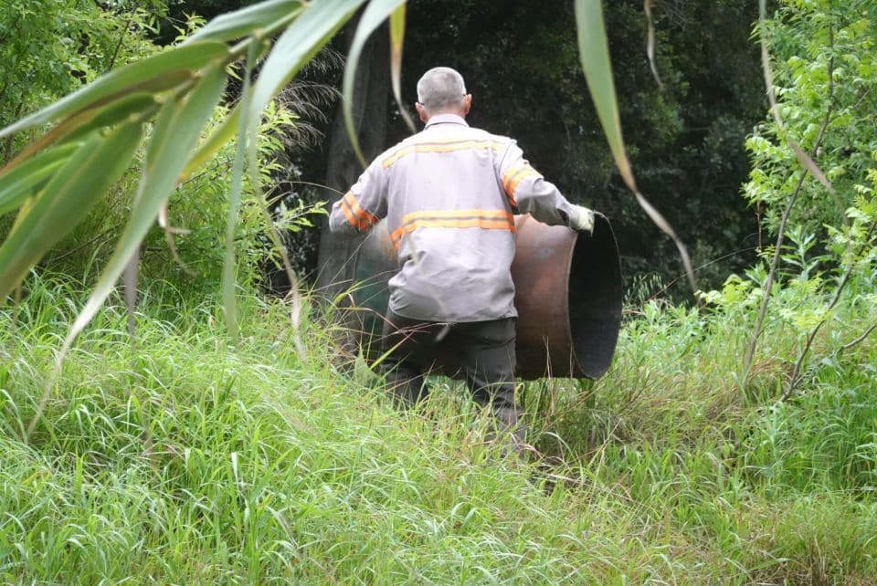 volunteer hauling large barrel
