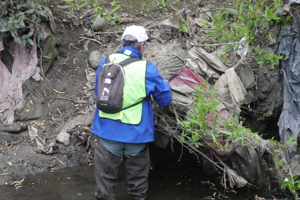 volunteer piling up trash at creekside